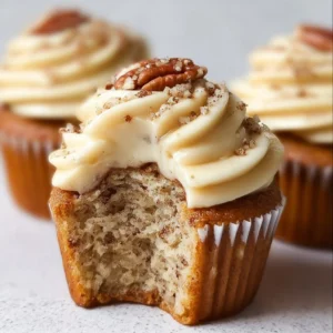 Delicious banana cinnamon pecan cupcakes topped with crunchy pecans.