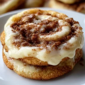 Delicious cinnamon roll cheesecake cookies on a plate, drizzled with icing.