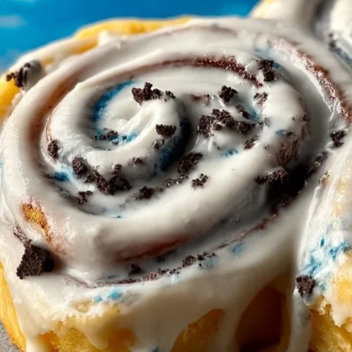 Delicious Cookie Monster Cinnamon Rolls topped with blue frosting and cookie pieces