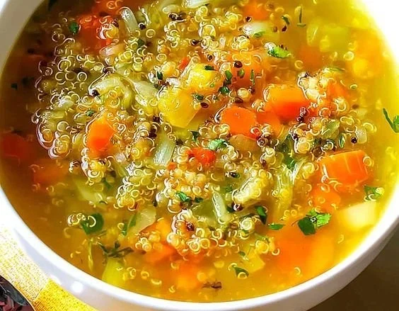 A bowl of delicious, steaming Garlic Soup garnished with fresh herbs.