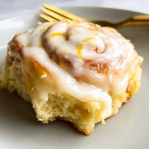 Homemade lemon sweet rolls drizzled with icing on a rustic wooden table